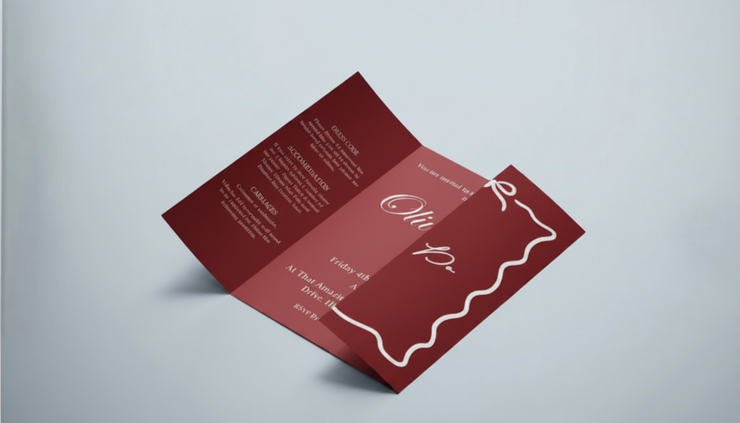 Burgundy gatefold wedding invitation with a hand-drawn wavy border and bow, by Meridian Studio